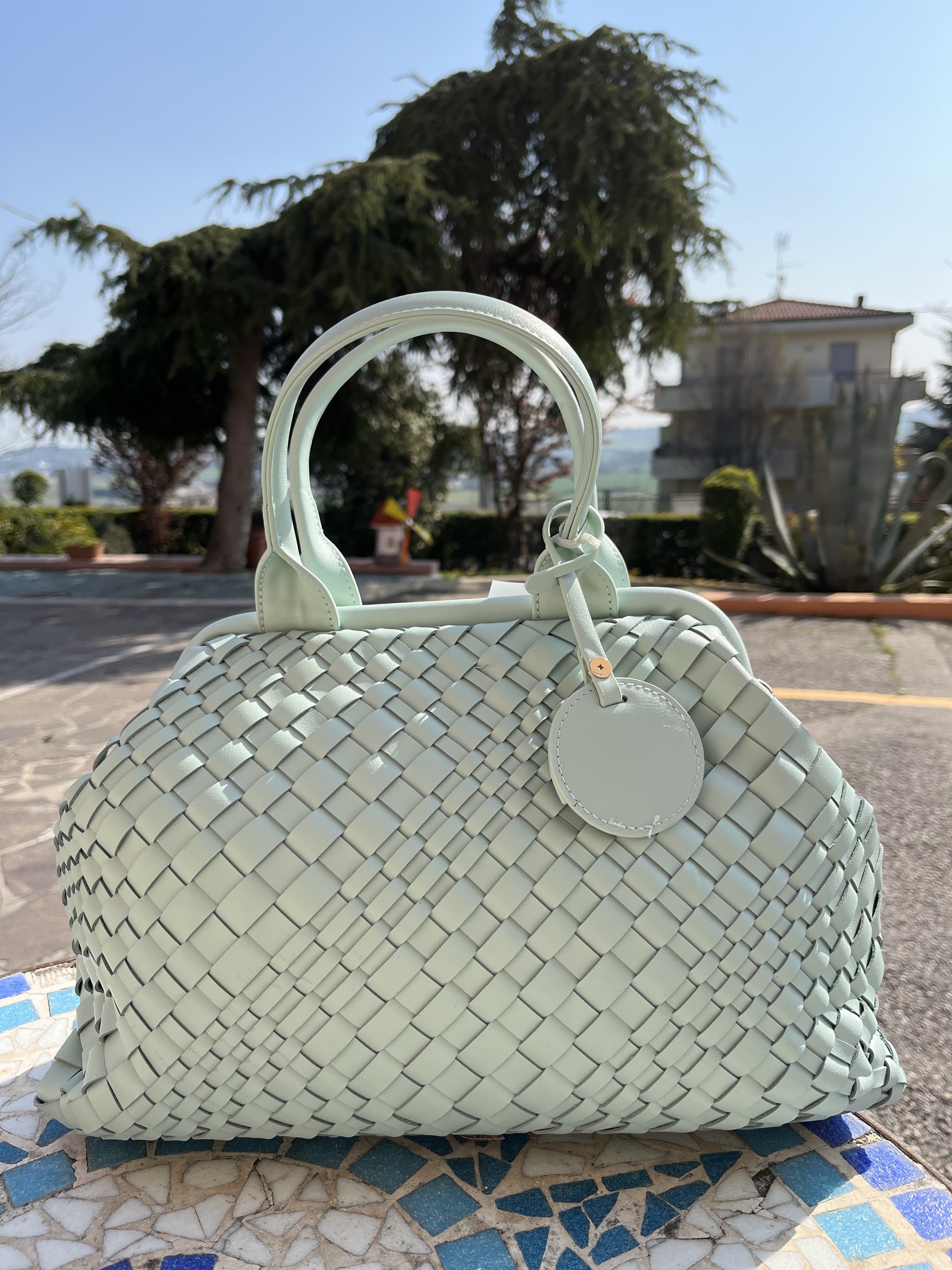 Bauletto con intreccio e accessorio pendente color acquamarina